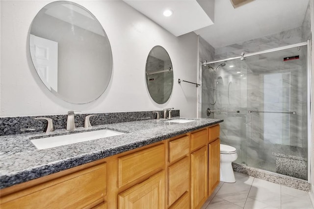 bathroom with a sink, a shower stall, toilet, and double vanity