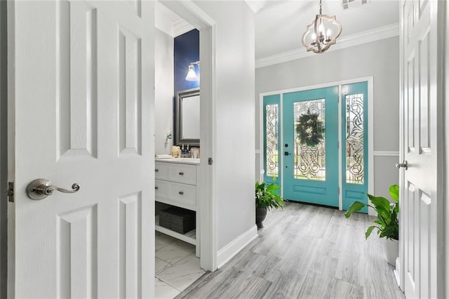 entryway featuring crown molding, a chandelier, and sink