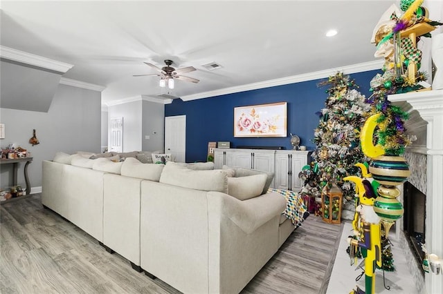 living room with crown molding, light hardwood / wood-style flooring, and ceiling fan