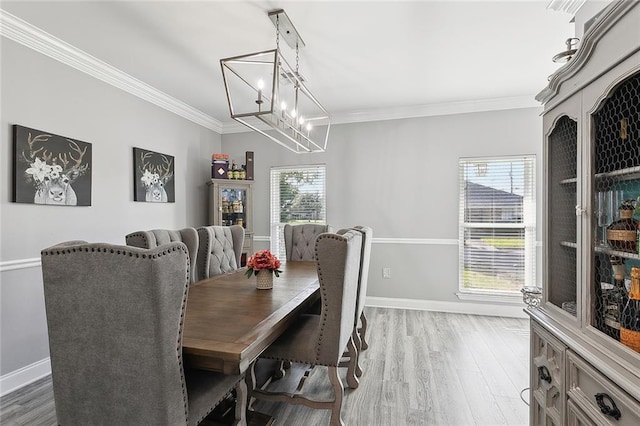 1125 Kingswood Dr, Westwego, LA 70094 - dining space with crown molding, baseboards, an inviting chandelier, and light wood-style floors
