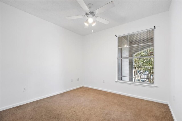 unfurnished room featuring carpet flooring, ceiling fan, and baseboards