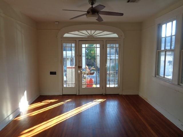 doorway to outside featuring dark wood-style floors, visible vents, and a ceiling fan