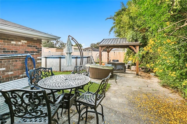 view of patio featuring a fenced in pool, outdoor dining area, a fenced backyard, and a gazebo