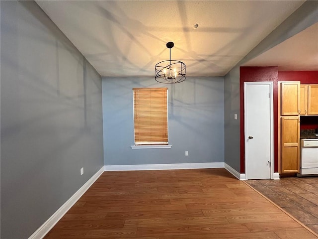 unfurnished dining area featuring hardwood / wood-style floors and an inviting chandelier