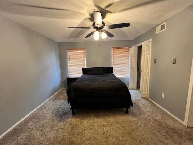 carpeted bedroom featuring ceiling fan and a textured ceiling