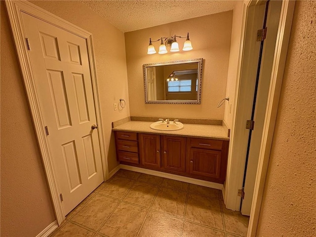 bathroom featuring vanity, tile patterned floors, and a textured ceiling