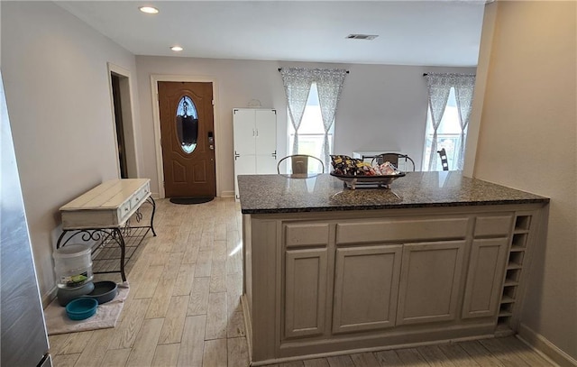 kitchen featuring dark stone countertops and light hardwood / wood-style flooring