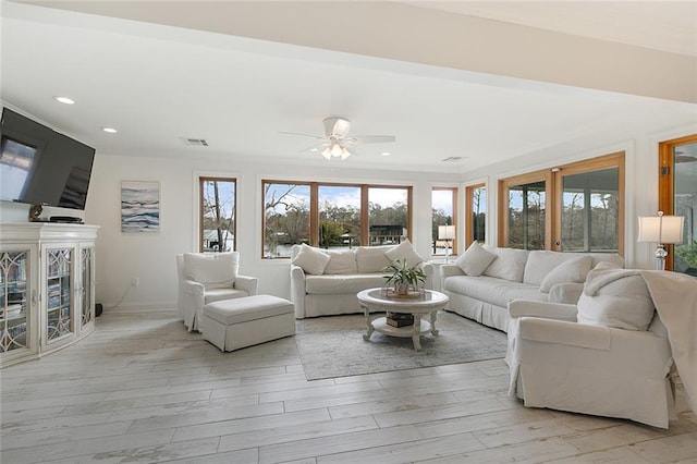 living room featuring crown molding, ceiling fan, and light wood-type flooring