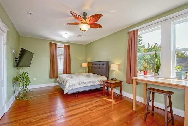 bedroom with hardwood / wood-style flooring and multiple windows