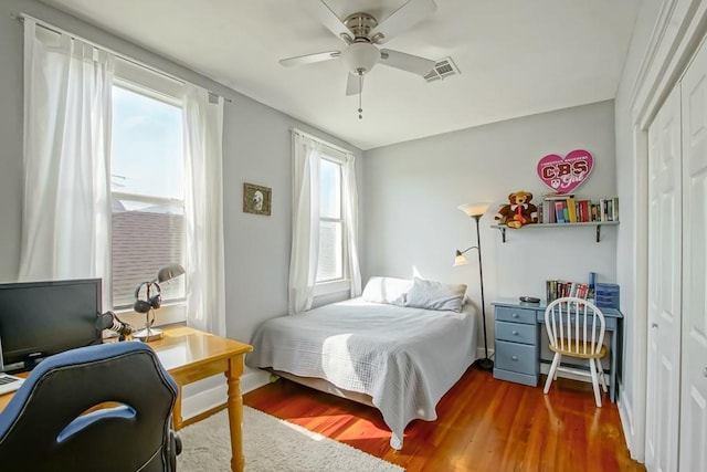 bedroom with dark hardwood / wood-style flooring, a closet, and ceiling fan