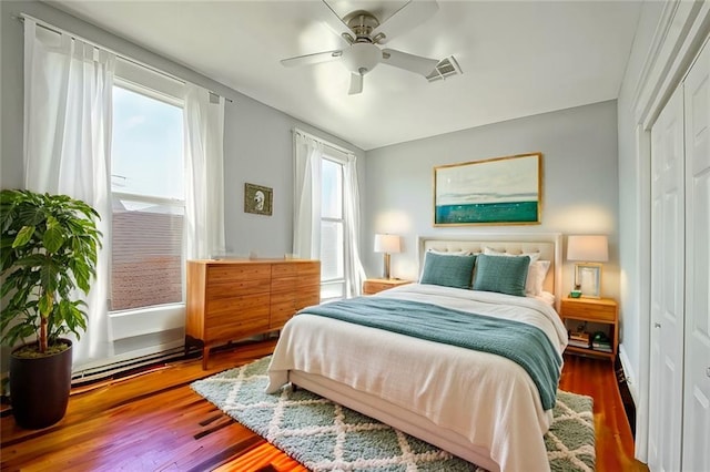 bedroom featuring hardwood / wood-style flooring, ceiling fan, and a closet