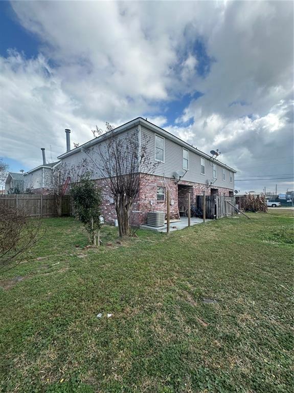 rear view of property featuring a patio and a yard