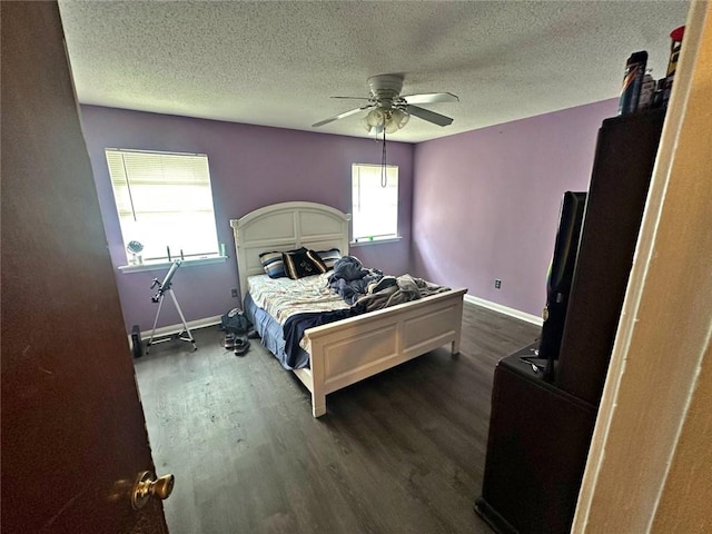 bedroom with dark wood-type flooring, ceiling fan, and a textured ceiling