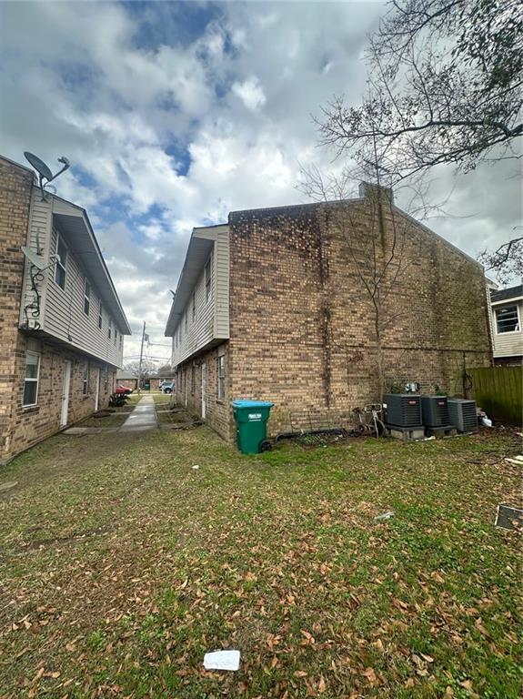 view of home's exterior featuring central AC unit and a yard