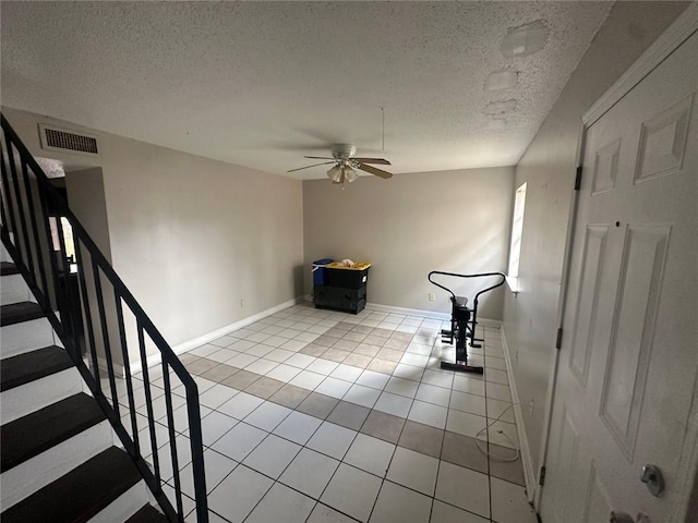 interior space with ceiling fan, a textured ceiling, and light tile patterned flooring