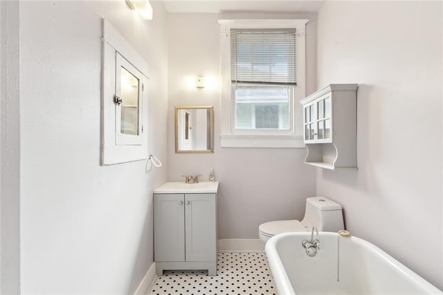 bathroom featuring vanity, a washtub, and toilet