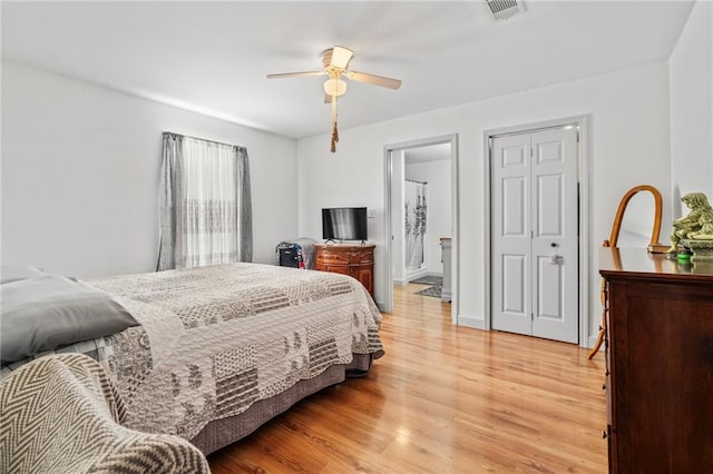 bedroom featuring ceiling fan, ensuite bath, and light wood-type flooring