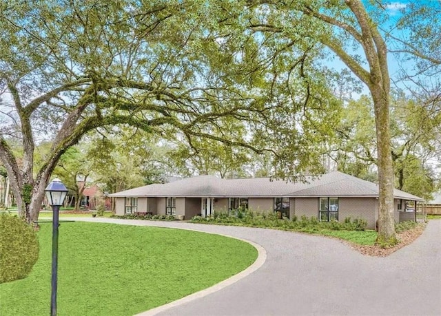 single story home with driveway and a front lawn