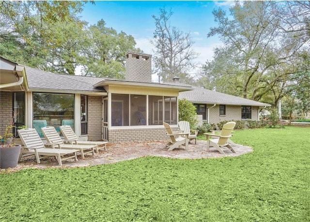 rear view of house with a yard, a sunroom, and a patio