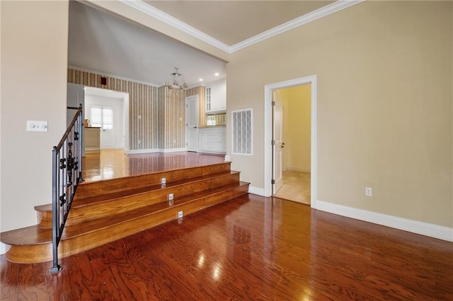 interior space featuring crown molding, wood-type flooring, and a chandelier