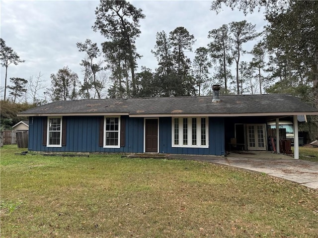 ranch-style home with an attached carport, board and batten siding, french doors, and a front yard