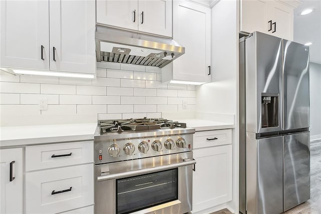 kitchen with under cabinet range hood, backsplash, appliances with stainless steel finishes, and light countertops