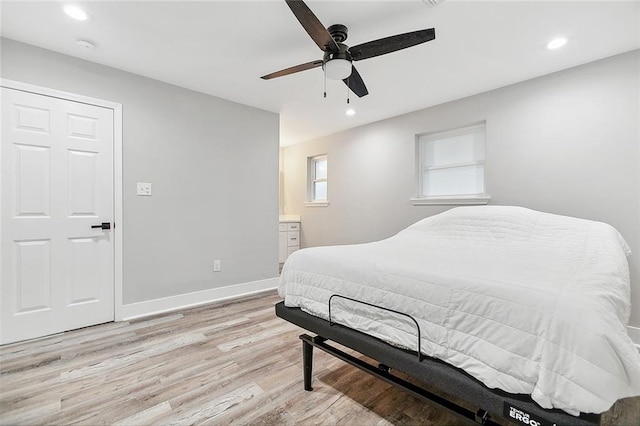 bedroom with recessed lighting, baseboards, ensuite bath, and light wood-style flooring