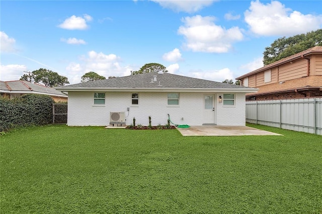 back of property with a patio area, a lawn, and a fenced backyard