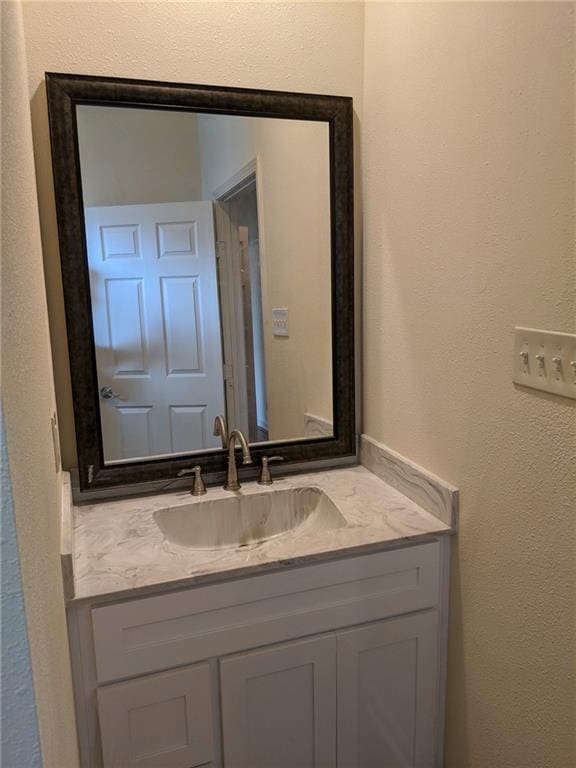 bathroom featuring a textured wall and vanity