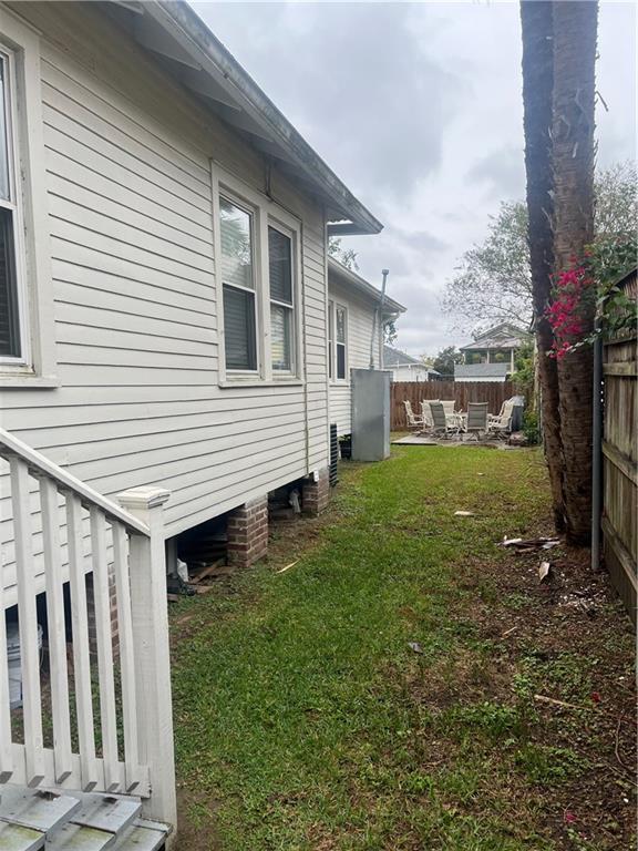 view of property exterior with a yard and a fenced backyard