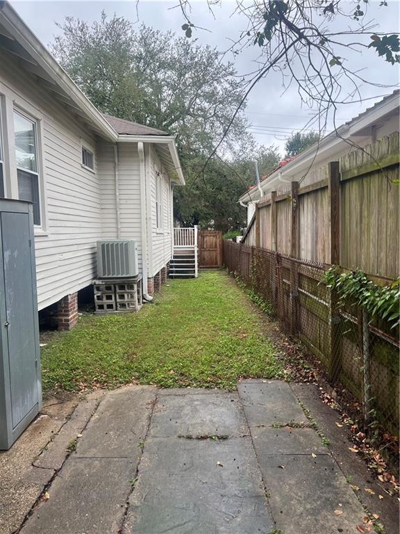 view of yard featuring a fenced backyard, a patio, and central air condition unit