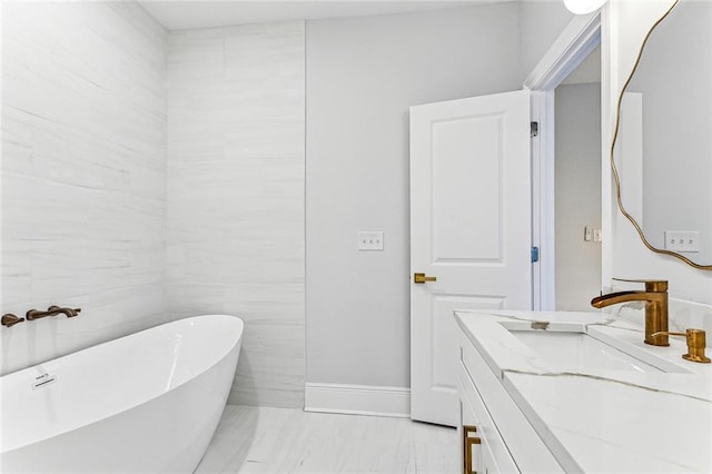 bathroom featuring vanity and a washtub