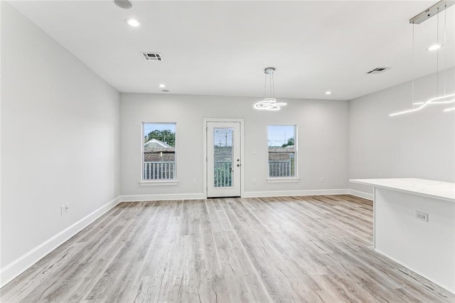 empty room with a healthy amount of sunlight and light hardwood / wood-style floors