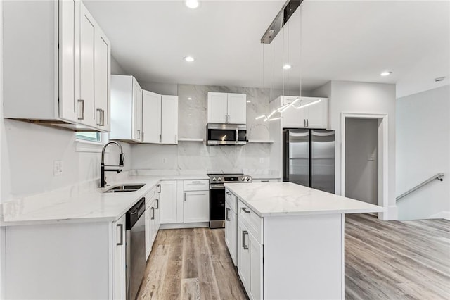 kitchen with sink, decorative light fixtures, a center island, stainless steel appliances, and white cabinets