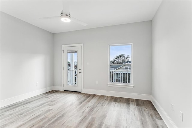 spare room with ceiling fan, light wood-type flooring, and a wealth of natural light