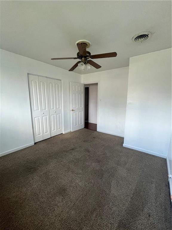 unfurnished bedroom featuring dark carpet, a closet, and ceiling fan