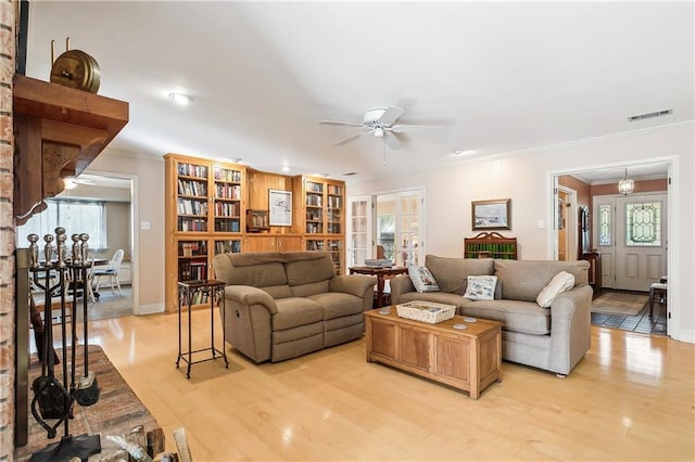 living room featuring ornamental molding, ceiling fan, and light wood-type flooring