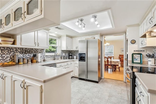 kitchen featuring sink, appliances with stainless steel finishes, white cabinetry, tasteful backsplash, and kitchen peninsula