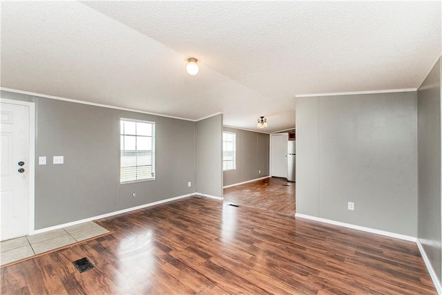 spare room with ornamental molding and dark wood-type flooring