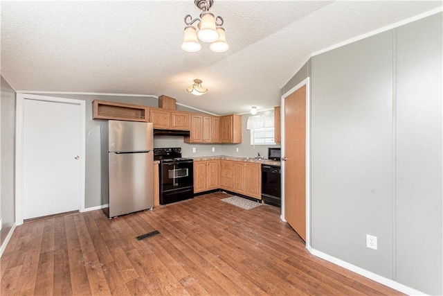 kitchen featuring wood-type flooring, black appliances, a textured ceiling, and vaulted ceiling