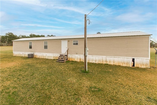 back of property with a yard and central air condition unit