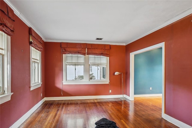 empty room with crown molding and wood-type flooring