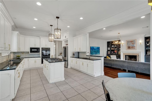 2809 Prytania St, New Orleans, LA 70115 - kitchen featuring a chandelier, black appliances, a sink, open floor plan, and light tile patterned floors