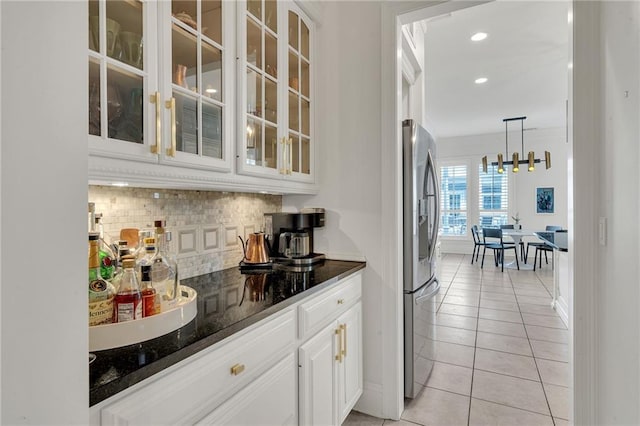 2809 Prytania St, New Orleans, LA 70115 - bar featuring tasteful backsplash, light tile patterned floors, stainless steel refrigerator with ice dispenser, hanging light fixtures, and a chandelier