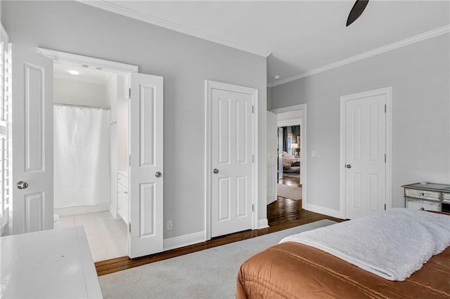 2809 Prytania St, New Orleans, LA 70115 - bedroom with crown molding, baseboards, wood finished floors, two closets, and ceiling fan