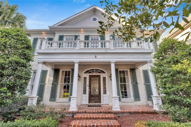2809 Prytania St, New Orleans, LA 70115 - greek revival house featuring a balcony, brick siding, and a porch