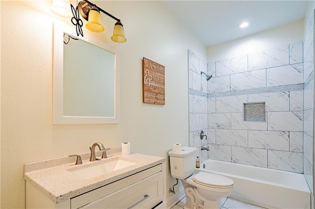 full bathroom featuring tiled shower / bath combo, vanity, and toilet