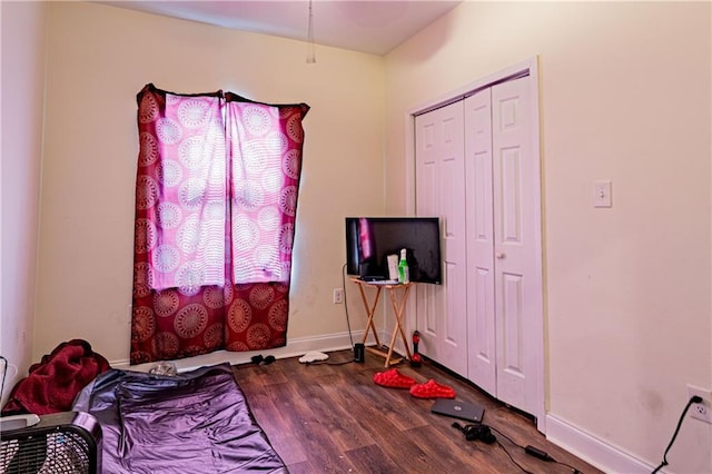 bedroom with dark wood-type flooring and a closet