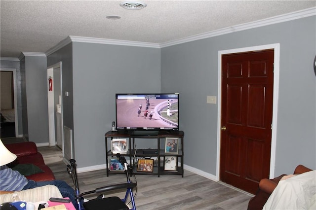 bedroom with ornamental molding, a textured ceiling, and light wood-type flooring