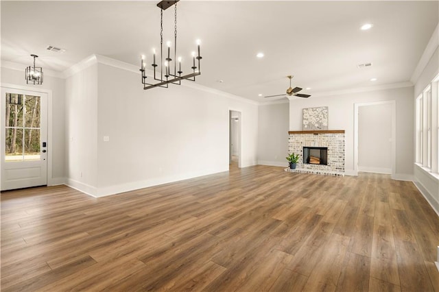 unfurnished living room featuring a brick fireplace, visible vents, and wood finished floors